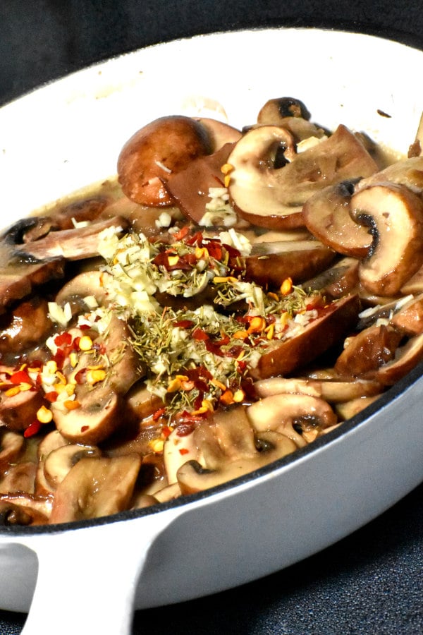 cooked mushrooms in a skillet with garlic and spices