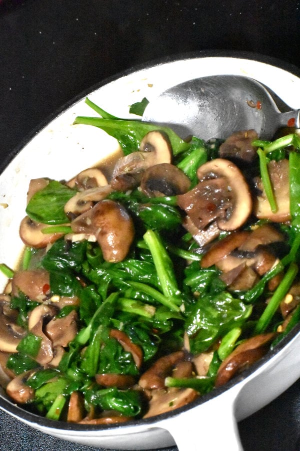 cooked mushrooms and spinach in a small skillet