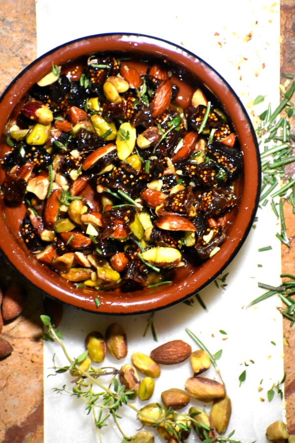 nuts, figs and honey mixed up in  a terra cotta bowl