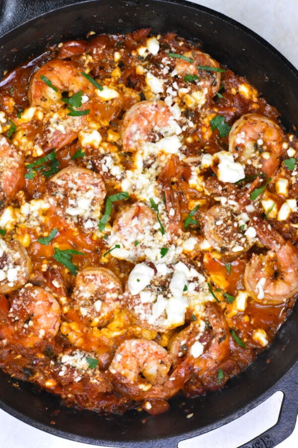 希腊虾和粗燕麦粉是一个不可思议的融合flavors. Plump shrimp in a beautifully flavored tomato sauce, topped with feta and served atop a creamy bed of grits.