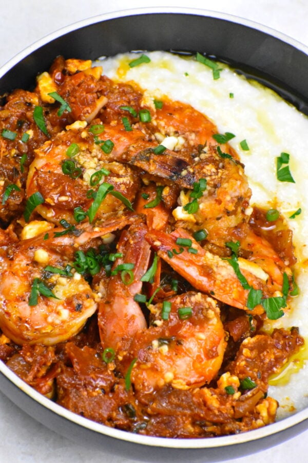 希腊虾和粗燕麦粉是一个不可思议的融合flavors. Plump shrimp in a beautifully flavored tomato sauce, topped with feta and served atop a creamy bed of grits.