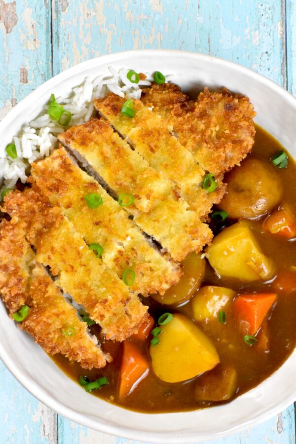 咖喱松是一种日式安慰食物，特色是裹上面包屑的猪排和美味的咖喱，所有这些都放在一层米饭上。太好吃了!