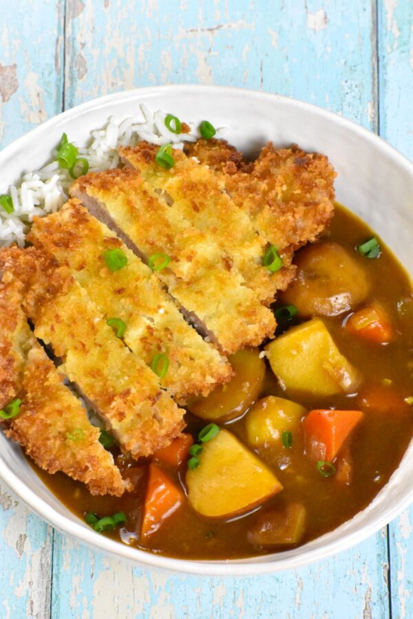 咖喱松是一种日式安慰食物，特色是裹上面包屑的猪排和美味的咖喱，所有这些都放在一层米饭上。太好吃了!