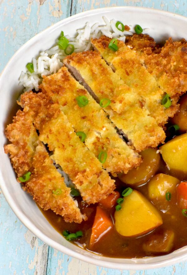 咖喱松是一种日式安慰食物，特色是裹上面包屑的猪排和美味的咖喱，所有这些都放在一层米饭上。太好吃了!